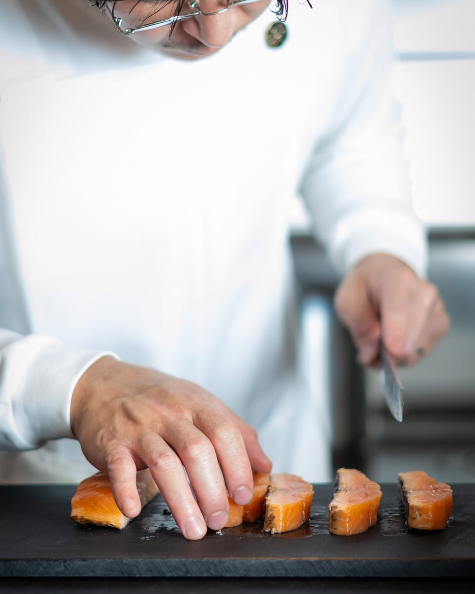 カウンターの向こうで料理を仕上げるSANADAの真田シェフの手元